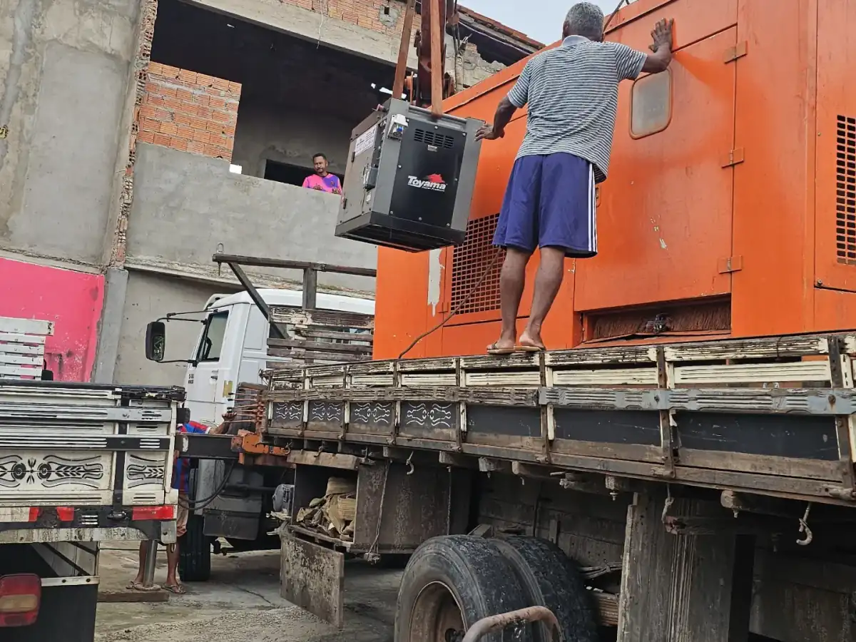 Equipe posicionando gerador no caminhão com munck para entrega em obra em São Luís, MA