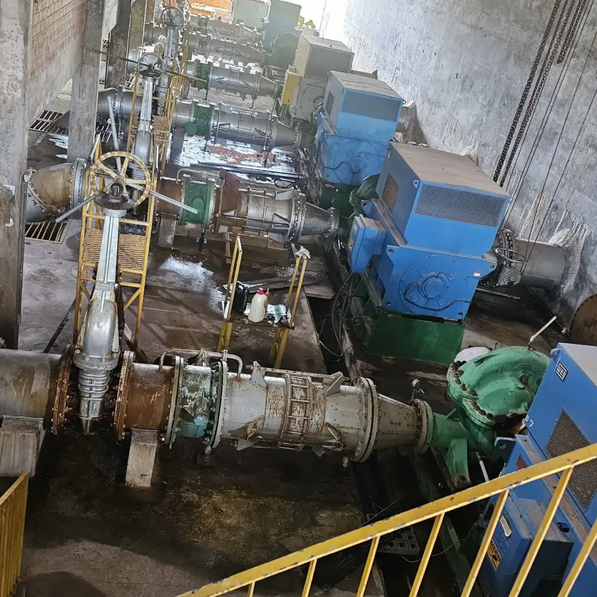Casa de bombas do sistema Italuís com grandes motores azuis e tubulações de adução